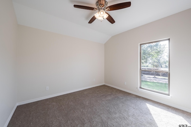 carpeted spare room with ceiling fan and vaulted ceiling