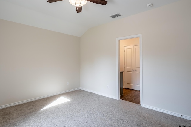 carpeted empty room with ceiling fan and lofted ceiling