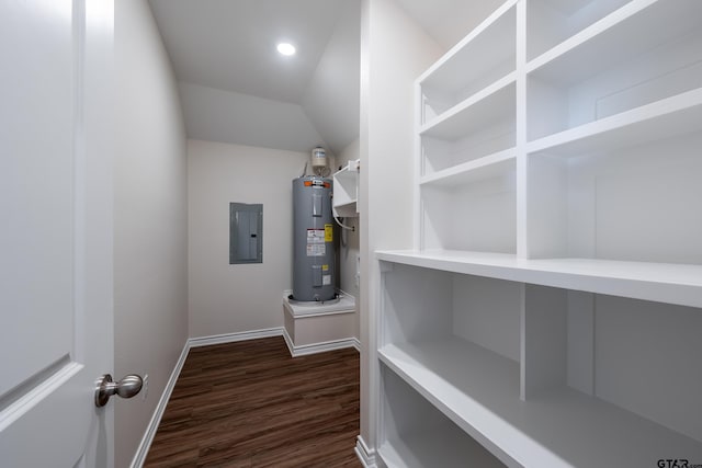 interior space featuring dark hardwood / wood-style flooring, electric water heater, electric panel, and vaulted ceiling