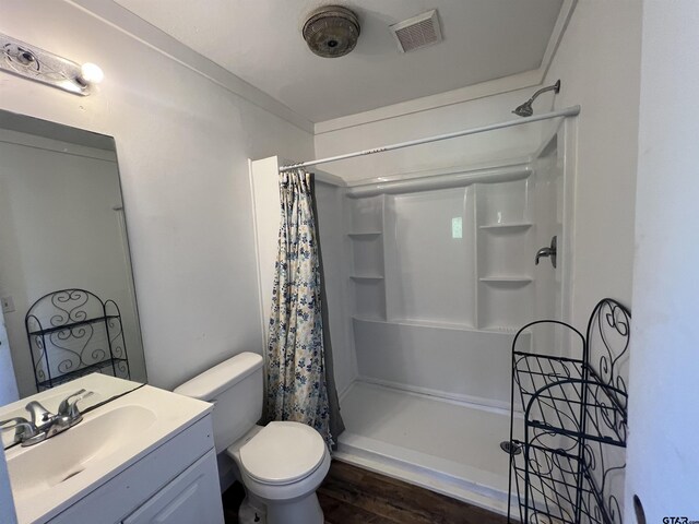 201 First St, Naples, TX 75568 - full bathroom with a shower with shower curtain, wood finished floors, vanity, and toilet