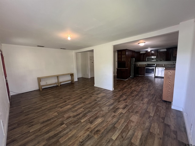 201 First St, Naples, TX 75568 - unfurnished living room with dark wood-style floors, a sink, and baseboards