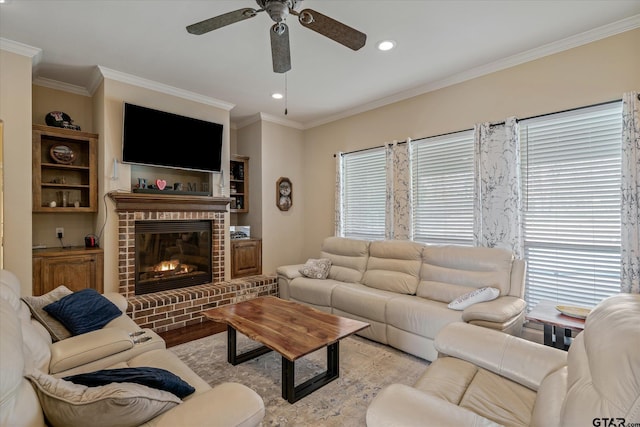 living room with a fireplace, crown molding, recessed lighting, a ceiling fan, and light wood-type flooring