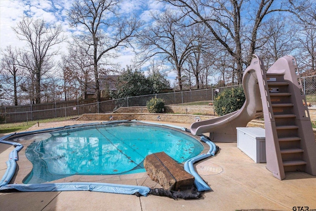 view of pool featuring a water slide, a patio area, a fenced backyard, and a fenced in pool