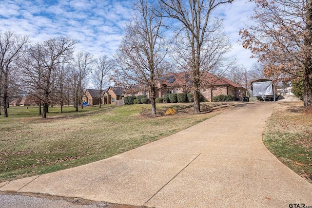 view of front of property featuring a residential view, driveway, and a front lawn