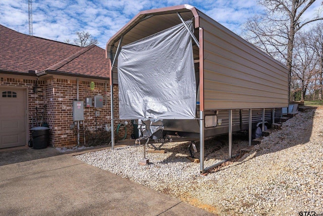 view of property exterior with a garage, a shingled roof, and brick siding