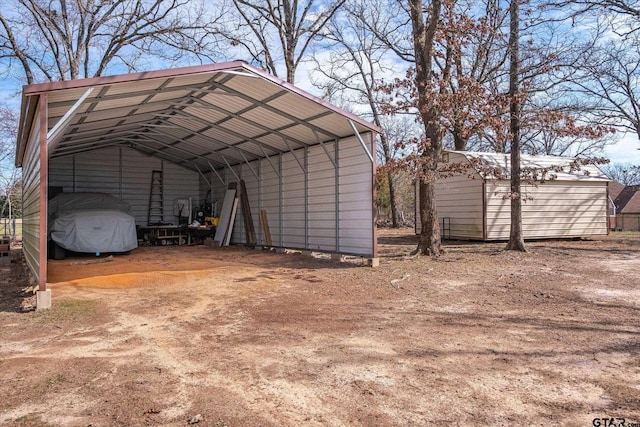 view of parking / parking lot with a storage shed, driveway, and a detached carport