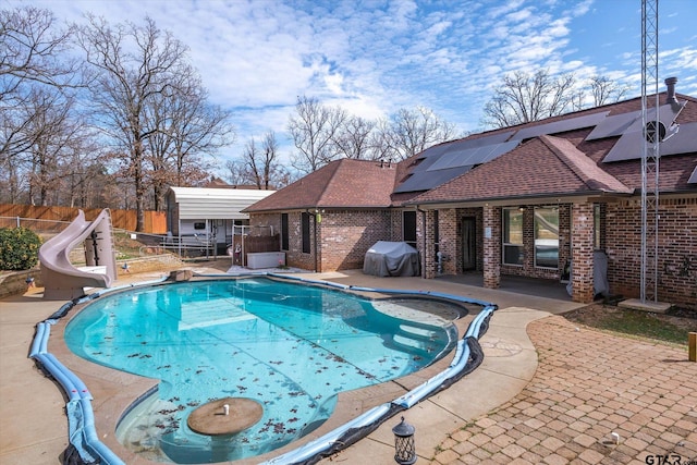 view of swimming pool with a fenced in pool, a patio, a fenced backyard, a grill, and a water slide