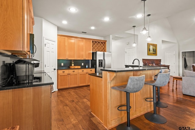 1509 Panther Creek Pass, Mount Vernon, TX 75457 - kitchen with stainless steel fridge, dark countertops, dark wood-style flooring, recessed lighting, and vaulted ceiling
