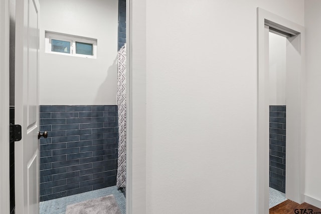 1509 Panther Creek Pass, Mount Vernon, TX 75457 - full bathroom with a shower with shower curtain, wainscoting, and tile walls
