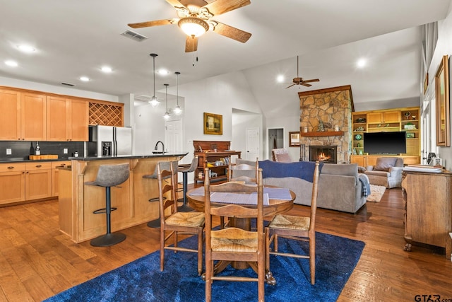 1509 Panther Creek Pass, Mount Vernon, TX 75457 - dining room featuring ceiling fan, dark wood-style floors, a stone fireplace, recessed lighting, and vaulted ceiling
