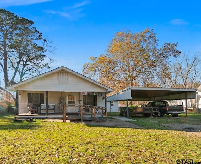 bungalow-style house with a carport, a porch, and a front yard