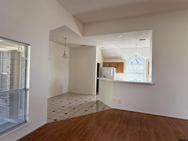 2414 Stillwater Dr, Mesquite, TX 75181 - unfurnished dining area with a textured ceiling, vaulted ceiling, and light wood-style floors