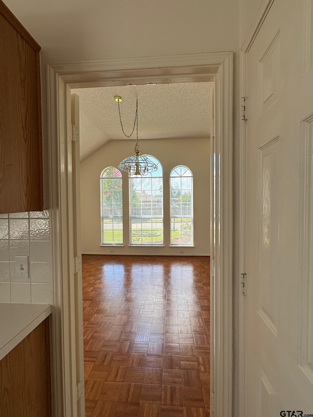 2414 Stillwater Dr, Mesquite, TX 75181 - hall featuring healthy amount of natural light, a textured ceiling, a chandelier, and lofted ceiling