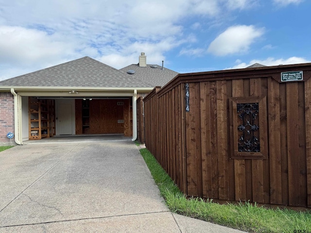 2414 Stillwater Dr, Mesquite, TX 75181 - view of property exterior with a shingled roof, concrete driveway, a garage, and a chimney