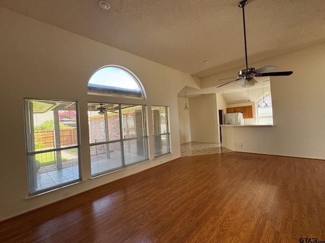2414 Stillwater Dr, Mesquite, TX 75181 - unfurnished living room featuring wood finished floors, plenty of natural light, a textured ceiling, and a ceiling fan