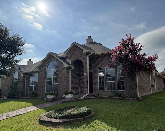 2414 Stillwater Dr, Mesquite, TX 75181 - view of front of house featuring brick siding, a chimney, and a front lawn