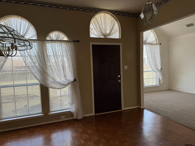 entrance foyer featuring dark parquet flooring and a textured ceiling