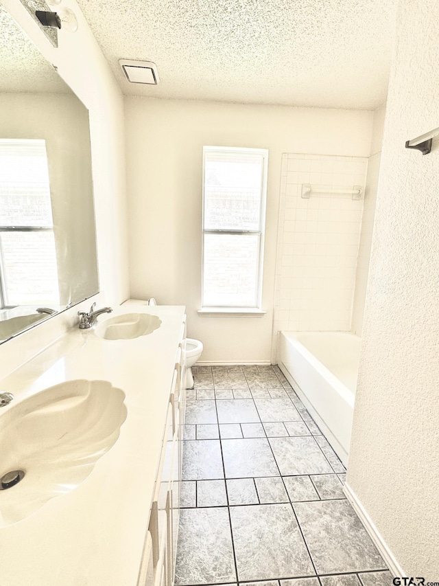 2414 Stillwater Dr, Mesquite, TX 75181 - full bathroom featuring a textured ceiling, double vanity, and bathing tub / shower combination