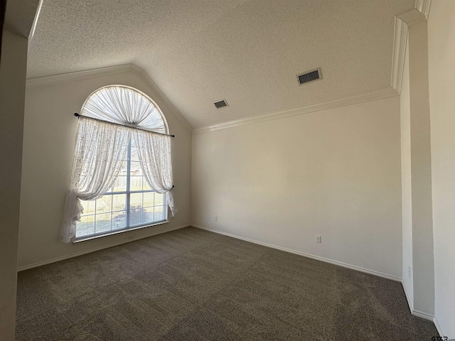 empty room with lofted ceiling, dark carpet, crown molding, and a textured ceiling