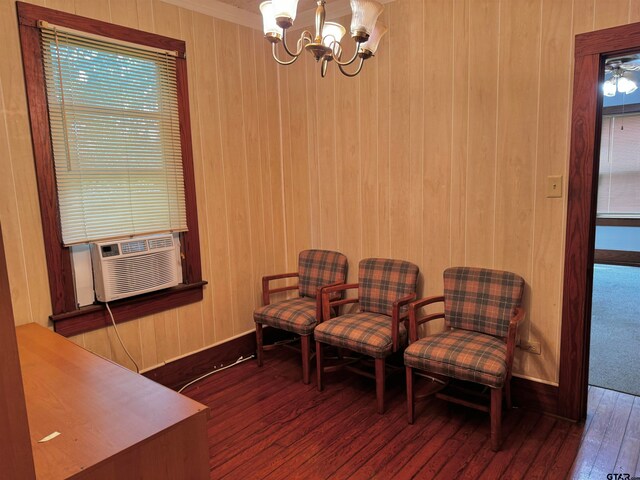 sitting room featuring dark hardwood / wood-style flooring, cooling unit, wooden walls, and an inviting chandelier