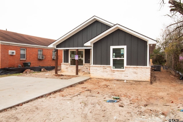 view of front of home with a wall mounted air conditioner and a patio area