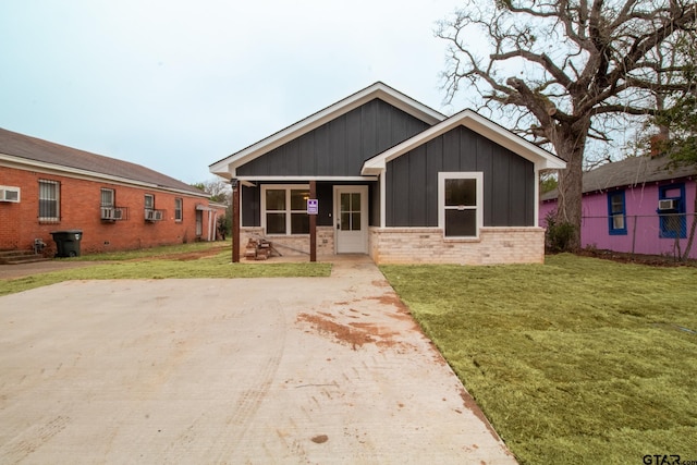 view of front of home with a front yard and cooling unit