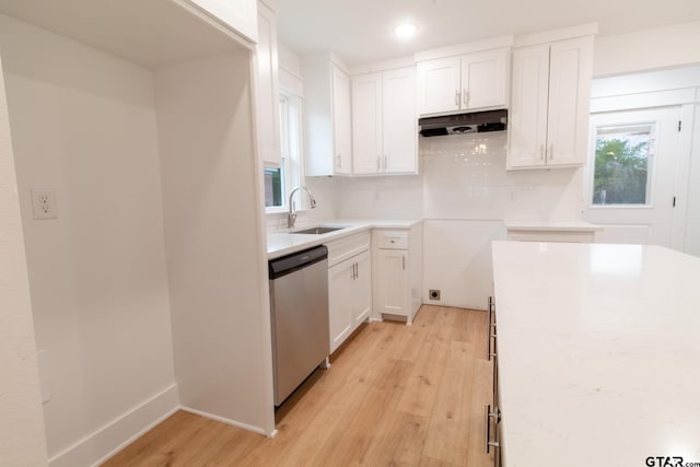 kitchen featuring tasteful backsplash, white cabinetry, sink, stainless steel dishwasher, and light hardwood / wood-style flooring