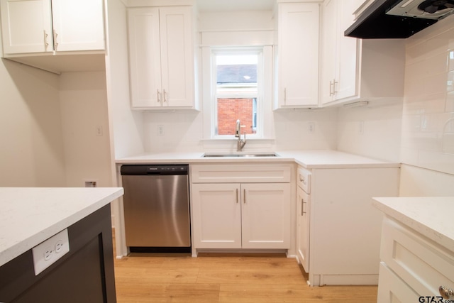 kitchen featuring extractor fan, white cabinetry, sink, stainless steel dishwasher, and light wood-type flooring