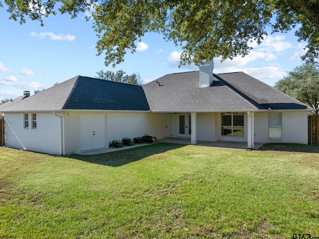 rear view of house featuring a lawn and a patio area