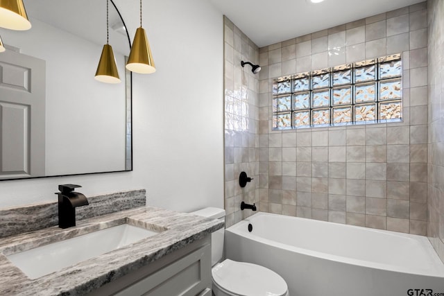 full bathroom featuring vanity, tiled shower / bath combo, and toilet