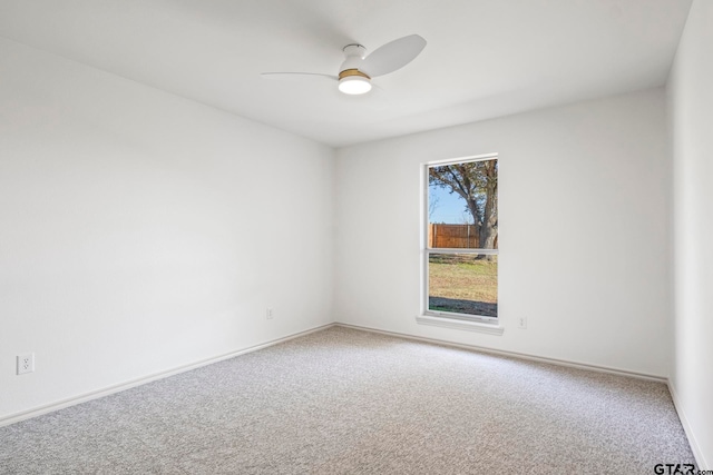 carpeted spare room featuring ceiling fan