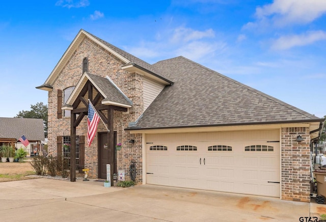 view of front of home featuring a shingled roof, brick siding, and driveway