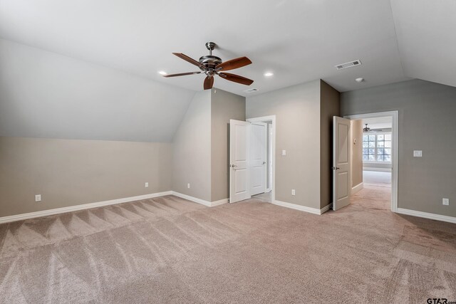 bonus room with vaulted ceiling, light carpet, and ceiling fan