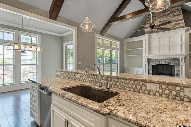 kitchen with dark wood-type flooring, decorative light fixtures, an island with sink, and white cabinets