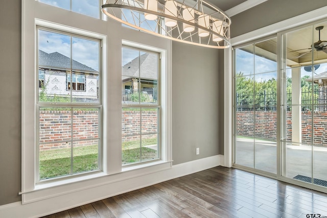 unfurnished dining area featuring hardwood / wood-style floors, plenty of natural light, and crown molding