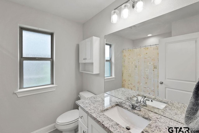 11317 Lindsey Gdns, Tyler, TX 75709 - bathroom with healthy amount of natural light, toilet, vanity, and baseboards
