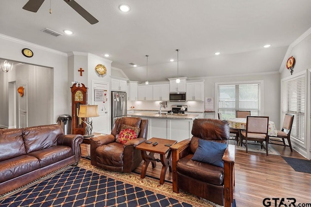 11317 Lindsey Gdns, Tyler, TX 75709 - living area with ceiling fan, lofted ceiling, crown molding, wood finished floors, and recessed lighting