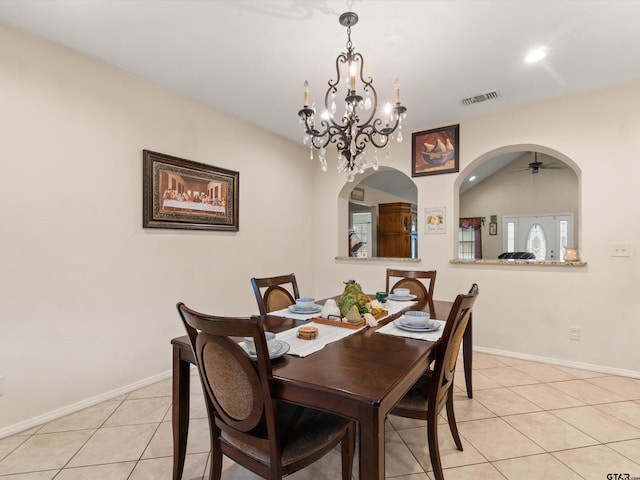 tiled dining room with an inviting chandelier