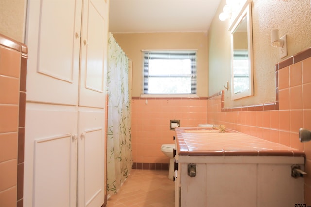 3008 Oak Knob Dr, Tyler, TX 75701 - full bath featuring tile walls, vanity, tile patterned floors, curtained shower, and a wainscoted wall