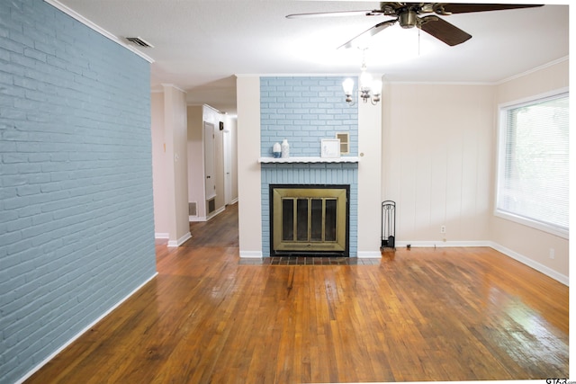 3008 Oak Knob Dr, Tyler, TX 75701 - unfurnished living room with a ceiling fan, wood-type flooring, ornamental molding, brick wall, and a chandelier