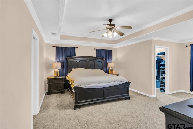 bedroom with ceiling fan, a spacious closet, crown molding, light colored carpet, and a closet