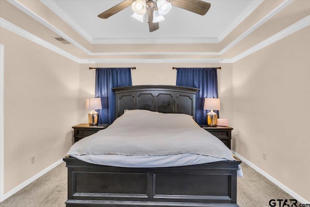 carpeted bedroom with ornamental molding, a tray ceiling, and ceiling fan