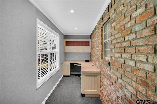 kitchen with ornamental molding, brick wall, and dark carpet