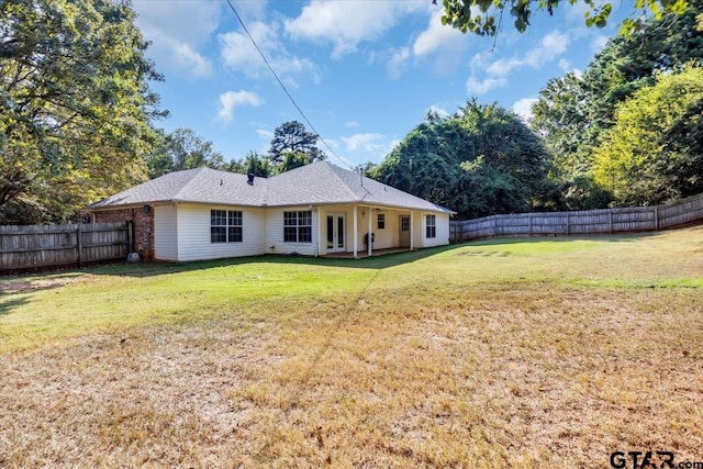 back of house with a lawn and a patio area