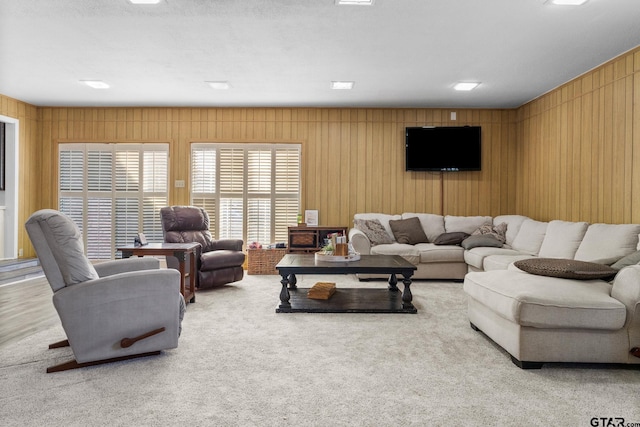 living room with wooden walls and light colored carpet