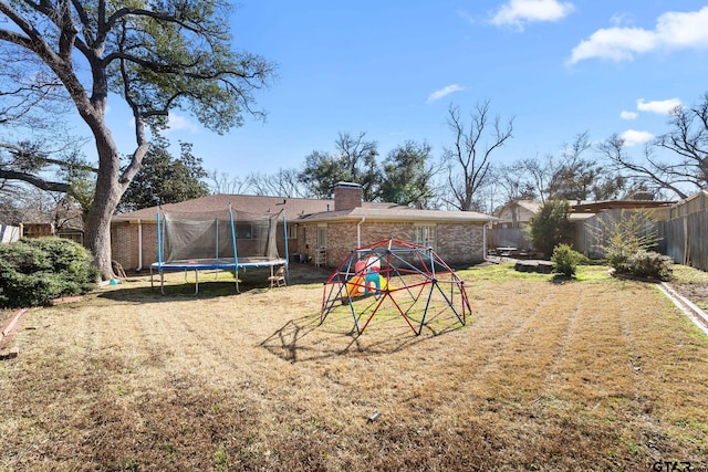 view of yard with a playground and a trampoline