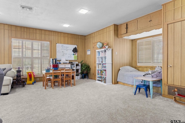 home office with light colored carpet, a textured ceiling, and wood walls