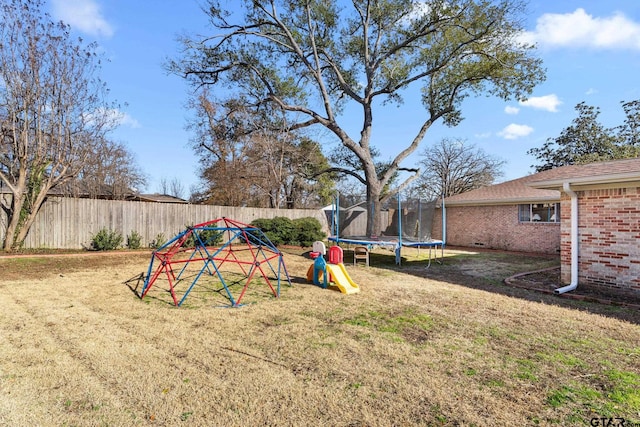 view of yard featuring a trampoline and a playground