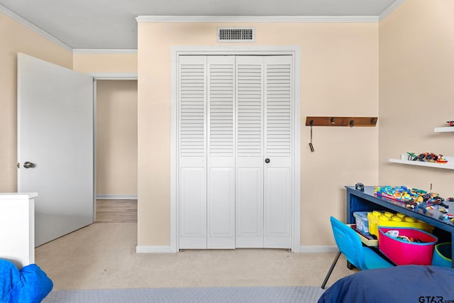 carpeted bedroom featuring crown molding and a closet