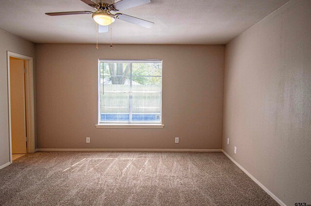 carpeted spare room with ceiling fan